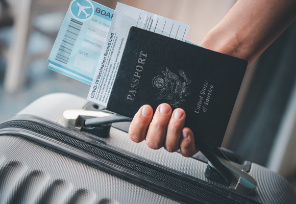パスポートと航空券と荷物を持つ人